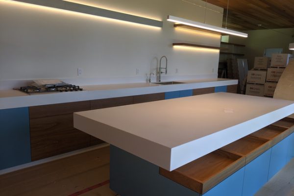 A kitchen with a granite counter top, wooden cabinets, and stainless steel appliances.